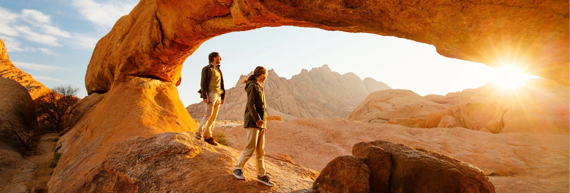 couple-travel-rock-formation-sunset-sunrise-man-woman-travel-leisure-hero-image